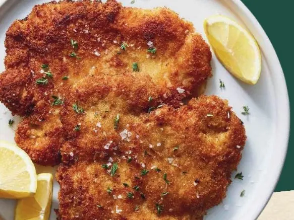 Zwei panierte Schnitzel mit Zitrone